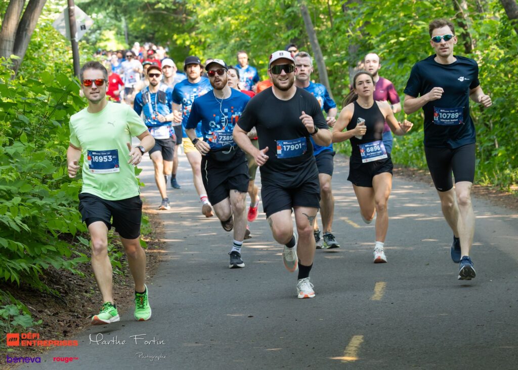 Group of runnersStarts a race on a sunny park path with bib numbers and colorful athletic gear.